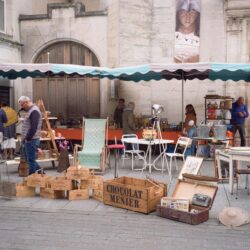 Lively street market in Nancy, France showcasing vintage goods and antiques.